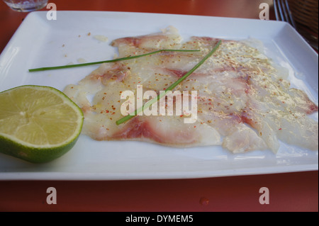 Il pesce bianco ceviche con un calce servita su una piazza piastra bianca Foto Stock