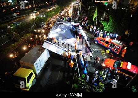 Jakarta, Indonesia. 22 apr 2014. I vigili del fuoco sono visibili su un cartellone che è crollato a causa di forte pioggia e forte vento a Giacarta, capitale dell'Indonesia, il 22 aprile 2014. Tabellone per le affissioni sopraffatto tre auto e una motocicletta, facendo in modo che due persone ferite e il traffico lungo la marmellata. Credito: Zulkarnain/Xinhua/Alamy Live News Foto Stock