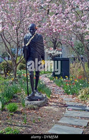 Una statua di Mohandas Gandhi in Union Square Park a New York fotografato in primavera con tulipani e magnolie. Foto Stock