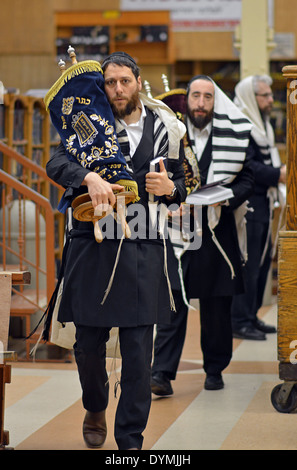 Religiosa ebraica uomini portano la Torah torna all'arca santa durante la mattina di Pasqua servizi presso la sinagoga Lubavitch in NYC Foto Stock