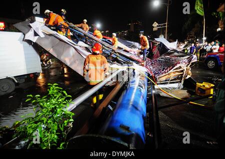 Jakarta, Indonesia. 22 apr 2014. I vigili del fuoco sono visibili su un cartellone che è crollato a causa di forte pioggia e forte vento a Giacarta, capitale dell'Indonesia, il 22 aprile 2014. Tabellone per le affissioni sopraffatto tre auto e una motocicletta, facendo in modo che due persone ferite e il traffico lungo la marmellata. Credito: Zulkarnain/Xinhua/Alamy Live News Foto Stock