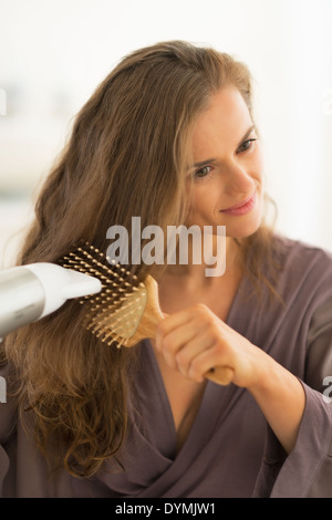 Giovane donna soffiare i capelli di essiccazione Foto Stock