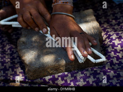 Donna boscimane facendo collane con uovo di struzzo Shell, Tsumkwe, Namibia Foto Stock