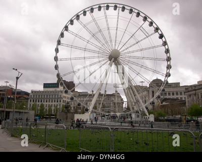 La ruota di Manchester in Piccadilly gardens contro il grigio di un cielo nuvoloso. Foto Stock