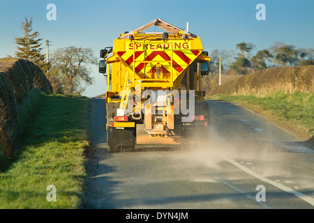 Gritter spandimento del sale su strade di campagna per fermare la formazione di ghiaccio su un inverni di notte e pericolose condizioni di guida. Foto Stock