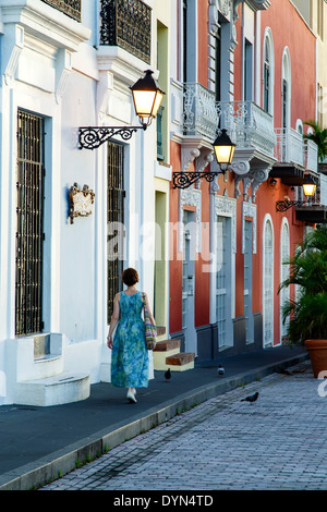 La donna a piedi dalle facciate colorate e lampade, Old San Juan, Puerto Rico Foto Stock