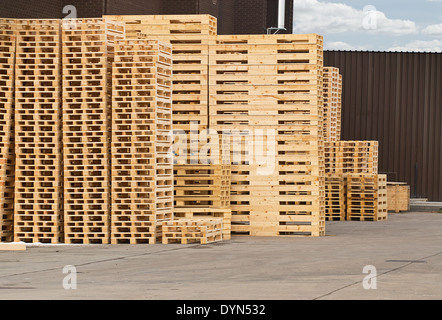 Stock pile di pallet in legno in un cantiere pronto per la frantumazione e riciclaggio di legna da ardere o ravvivare Foto Stock