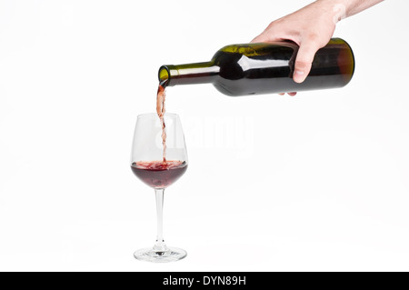 Il vino rosso è versata nel bicchiere di vino Foto Stock