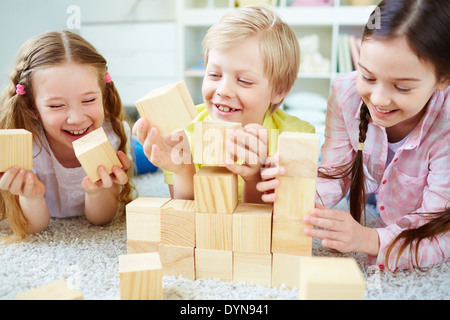 Tre piccoli amici a giocare con mattoni in legno Foto Stock