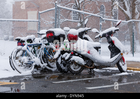 Coperta di neve parcheggiato per ciclomotori e biciclette Foto Stock