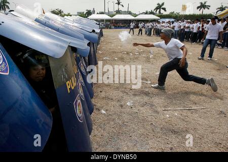 Pasay City, 23 aprile. 28 apr 2014. La simulazione di una attivista getta una bomba di acqua a poliziotti durante il filippino della polizia nazionale civile gestione di disturbo (PNP-CDM) Concorrenza in Pasay City, Filippine, 23 aprile 2014. Il Philippine National Police (PNP) membri a prepararsi per la settimana di manifestazioni di protesta contro la visita di Stato degli Stati Uniti Il presidente Barack Obama dal 28 aprile 2014. © Rouelle Umali/Xinhua/Alamy Live News Foto Stock