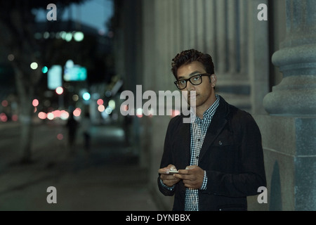 L'uomo tramite telefono cellulare su una strada di città Foto Stock