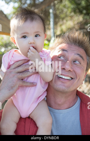 Padre giocando con la bambina all'aperto Foto Stock