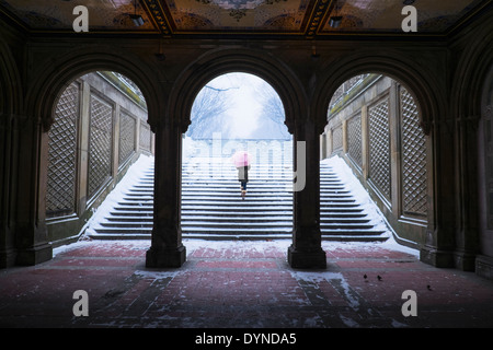 Donna asiatica salire a piedi a passi nella neve Foto Stock