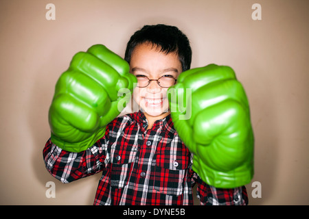 Razza mista ragazzo giocando con toy guantoni da pugilato Foto Stock