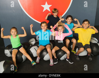 Bambini flettendo i loro muscoli in palestra Foto Stock