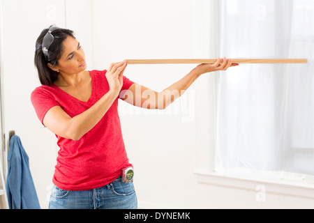 Razza mista donna esame di asse di legno Foto Stock