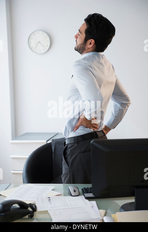Razza mista imprenditore strofinando il suo ritorno in ufficio Foto Stock