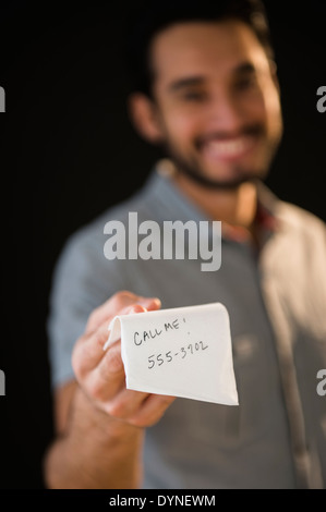 Razza mista uomo dare il numero di telefono sul tovagliolo Foto Stock