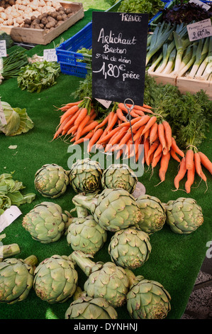 Carciofi e carote in vendita su un mercato Stall a Moelan-Sur-Mer, Bretagna, Francia Foto Stock