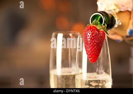 Il riempimento di bicchieri di champagne da una donna. Foto Stock