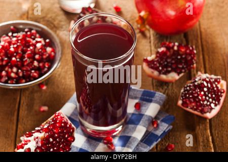 Organico sano succo di melograno in un bicchiere Foto Stock