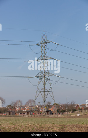 Un enorme pilone di elettricità in stretta prossimità di proprietà residenziali nelle Midlands. Foto Stock