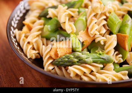 Cena di pasta con asparagi verdi, vegan cold cut e aglio salsa di noci. Foto Stock