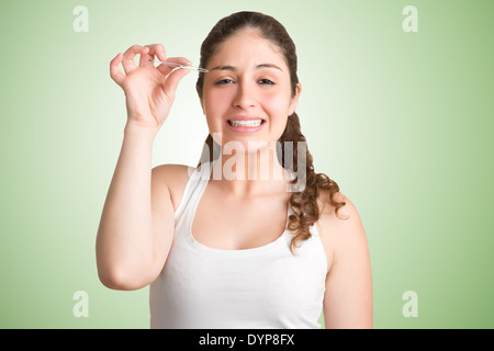 Donna spennatura le sopraciglia con un look painfull sul suo viso, isolato Foto Stock