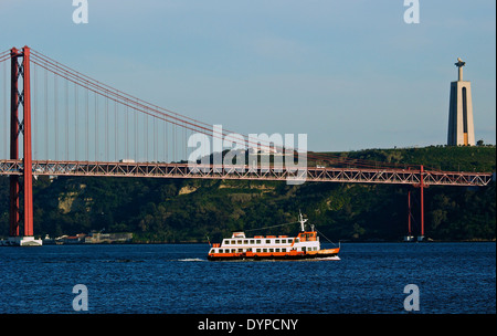 Traversata in traghetto il Tago (TEJO) fiume nella parte anteriore del 25 aprile bridge con la gigantesca statua del Cristo sulla banca del sud a Lisbona Foto Stock