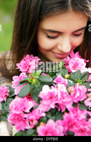 Giovane donna profumati fiori di colore rosa Foto Stock