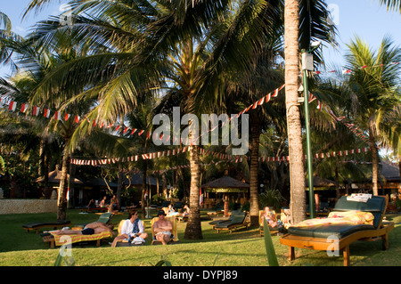 I turisti a prendere il sole su uno dei numerosi hotel di Legian. Surfisti sulla spiaggia di Kuta. Lezioni di surf. Bali. Kuta si trova a Coastal Foto Stock