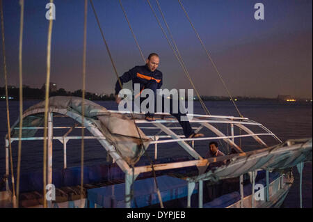 (140424) -- Il Cairo, 24 aprile 2014 (Xinhua) -- Boatman Hesham pack sailcloth fino a un dock dal fiume Nilo nel quartiere di Maadi al Cairo, capitale dell Egitto, il 17 marzo 2014. La famiglia Yamama da Giza ha vissuto sul Fiume Nilo per quasi un secolo. Attualmente Abdel Majid e suo fratello Abed Rabbo eseguire la barca a vela business per i turisti a un dock nel quartiere di Maadi del Cairo. Il Yamama fratelli e i piccoli battellieri noleggio essi hanno visto un drammatico calo di affari come risultato della depressione nel turismo dal 2011, quando la rivoluzione è iniziata in tutto il paese. (Xinhua/Pan Chaoyue) (djj) Foto Stock