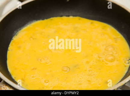 Una padella piena di uova strapazzate pronti per la cottura Foto Stock