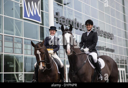 Amburgo, Germania. 24 apr 2014. Bianca Groissl Faerber sul suo cavallo Eschnapur (L) e Kerstin Schneider Dolly Parton ride passato il centro fieristico di Amburgo, Germania, 24 aprile 2014. Il equestre HansePferd fiera sarà aperto dal 25 aprile al 27 aprile a Hamburg exhibition centre. Foto: Axel HEIMKEN/dpa/Alamy Live News Foto Stock