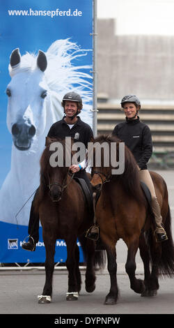 Amburgo, Germania. 24 apr 2014. Corinna Langer e Helmut Bramesfeld siedono sui loro cavalli islandesi davanti al centro fieristico di Amburgo, Germania, 24 aprile 2014. Il equestre HansePferd fiera sarà aperto dal 25 aprile al 27 aprile a Hamburg exhibition centre. Foto: Axel HEIMKEN/dpa/Alamy Live News Foto Stock