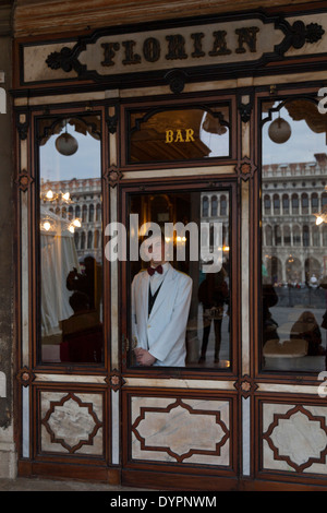 Cameriere sorridente attraverso la finestra del famoso Caffè Florian a Venezia Foto Stock