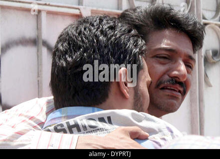 Persone in lutto reagiscono in un ospedale dopo l uccisione dei loro parenti in un suicidio blast nel vecchio Sabzi Mandi area di Karachi verso sinistra di quattro persone tra cui ispettore di polizia Tanoli Shafiq morti e 15 altri feriti a ospedale Jinnah mortuaria a Karachi il giovedì, 24 aprile 2014. L'esplosione ha ucciso ufficiali di polizia Shafiq Tanoli e altri tre feriti e 15 altri compresi Tanoli le tre protezioni, bomba Tanoli mirate e bomba Tanoli mirati come gli alti ufficiali di polizia, Raja Umar Khitab, confermata. Foto Stock