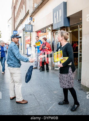 Exeter, Regno Unito. 24 apr 2014. Un attivista mani fuori un foglietto esterno il divario negozio di abbigliamento a Exeter per evidenziare Gap il rifiuto di firmare l' accordo commerciale che potrebbero migliorare le condizioni per la fabbrica di indumento i lavoratori. Credito: Clive Chilvers/Alamy Live News Foto Stock