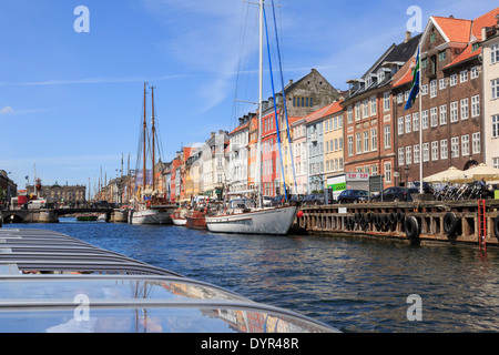 I turisti canal sightseeing tour in barca passando di vecchi edifici in banchina a Nyhavn, Copenaghen, Zelanda, Danimarca, Europa Foto Stock