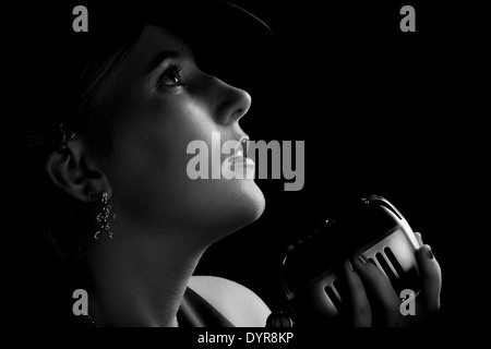 Bellissimo canto jazz donna con fedora e stile retrò microfono Foto Stock
