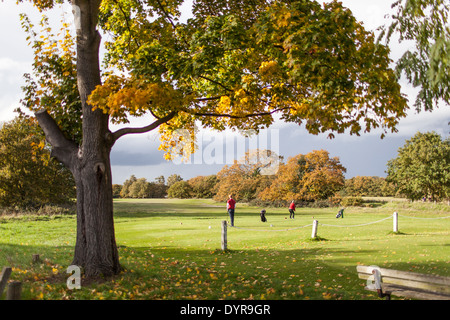 Gli amanti del golf giocare in un bellissimo paesaggio autunnale presso un campo da golf a Wimbledon, London, Regno Unito Foto Stock