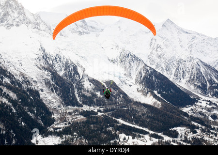 Un turista, paraglides in tandem con una guida al di sopra della valle di Chamonix Mont Blanc, decolla da Planpraz. Foto Stock