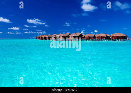 Le Ville Overwater in blu laguna tropicale di acqua poco profonda Foto Stock