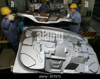 Lavoratori cinesi timbro della parte del corpo a un minivan linea di produzione di Hafei Automobile Manufacturing Foto Stock