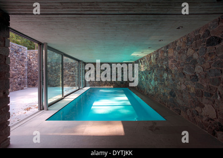 Piscina interna con pietra surround e porte in vetro Foto Stock