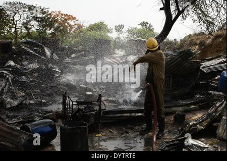 New Delhi, India. Xxv Aprile, 2014. Un vigile del fuoco tenta di spegnere un incendio in una delle baraccopoli cluster nel sud di New Delhi Vasant Kunj area, l'India, il 25 aprile 2014. Il fuoco senza visceri intorno 500 hutments, un funzionario detto. Incidenti o lesioni personali è stato riferito finora. Credito: Zheng Huansong/Xinhua/Alamy Live News Foto Stock