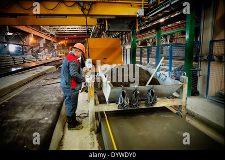 Lavoratore opera la macchina per il riempimento di piastre Foto Stock