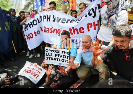 Manila, Filippine. Xxv Aprile, 2014. Gli uomini mostrano le loro mani macchiate con animale di sangue come i gruppi militanti hanno protestato davanti all'ambasciata degli Stati Uniti a Manila contro la presenza di truppe USA nelle Filippine. Il presidente statunitense baracca Obama sarà in visita nelle Filippine come sua ultima tappa del suo tour in Asia. Credito: Mark Fredesjed R. Cristino/Pacific Press/Alamy Live News Foto Stock