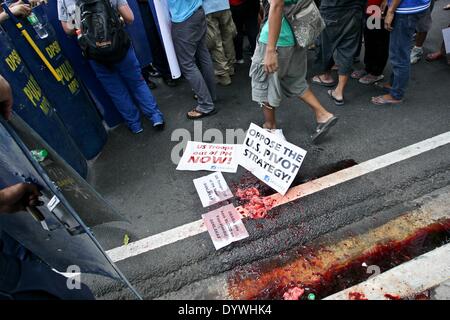 Manila, Filippine. Xxv Aprile, 2014. I gruppi militanti lasciano i loro cartelloni su suolo coperto di sangue animale e organi come essi hanno protestato davanti all'ambasciata degli Stati Uniti a Manila contro la presenza di truppe USA nelle Filippine. Il presidente statunitense baracca Obama sarà in visita nelle Filippine come sua ultima tappa del suo tour in Asia. Credito: Mark Fredesjed R. Cristino/Pacific Press/Alamy Live News Foto Stock